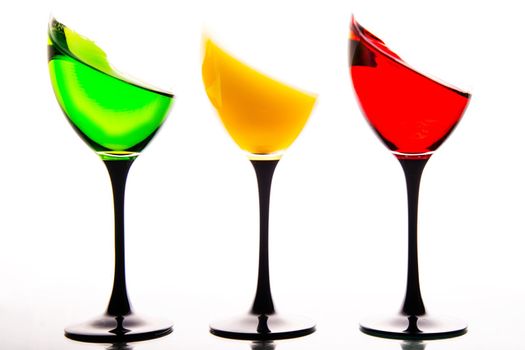 three wine glasses filled with the colors of traffic lights.