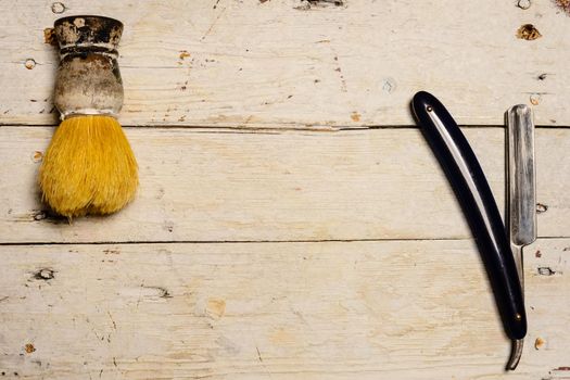 Straight Razor and shaving supplies on wooden background