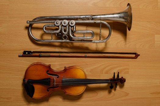 Broken trumpet and violin on the wooden floor.