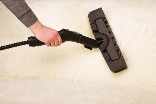 Young woman with a steam cleaner cleans the carpet on the couch - Image