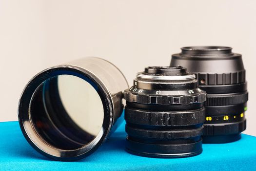 three old lenses close up on blue.