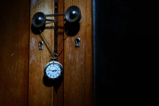 Pocket watch hanging on a chain on a cabinet handle