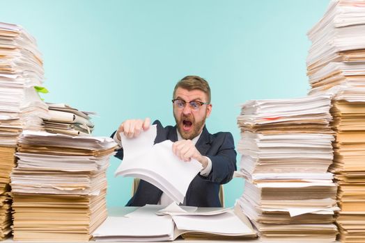 Business executive working in the office and piles of paperwork, he is overloaded with work. Breaks a paper contract and quits his job - image