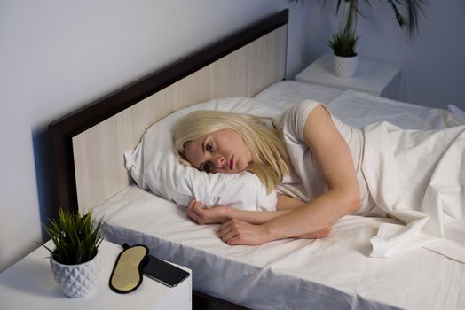 young beautiful woman at home bedroom lying in bed late at night trying to sleep suffering insomnia sleeping disorder or scared on nightmares looking sad worried and stressed- image