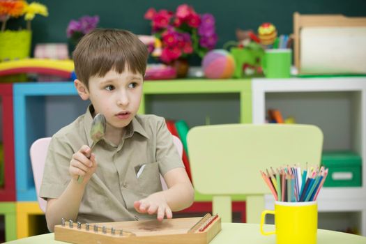 A child with a musical instrument. Boy learn to play dulcimer