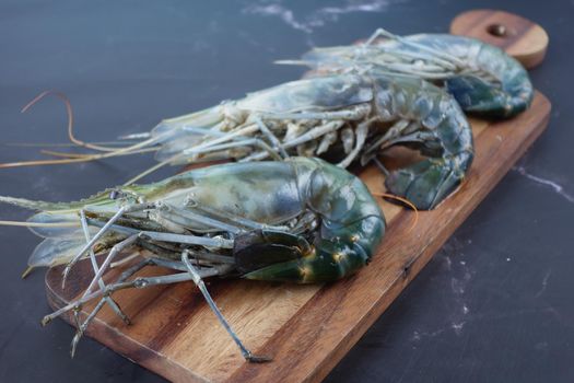 close up of king prawn on a chopping board on table..