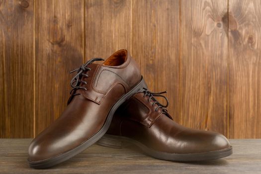 Fashionable men's classic brown shoes on a wooden background - image