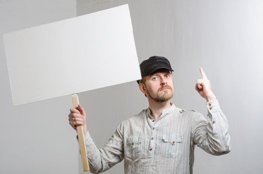 Work young man points finger on a blank banner - isolated on white.