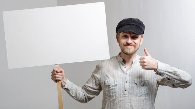 Amazed bearded man showing thumb up and leaning at copy space while standing against white background