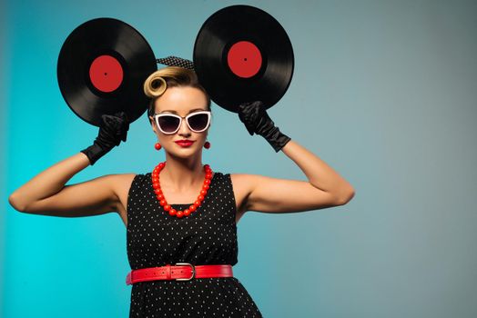 A photo of glamorous pin-up girl holding vinyl LP in hand - image