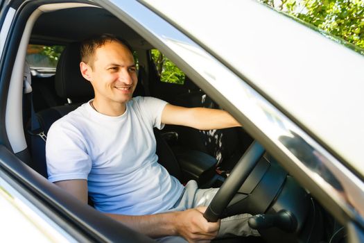 Portrait of an handsome guy driving his car