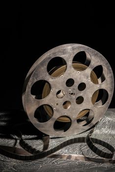 35 mm film reel with dramatic lighting on a dark background - image