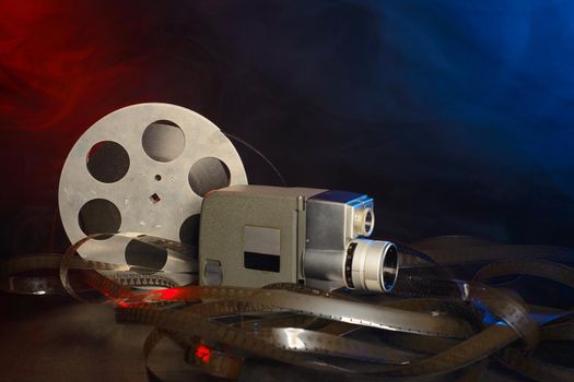 8 mm movie camera with a reel of film in blue and red smoke.