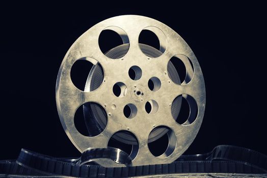 35 mm film reel with dramatic lighting on a dark background - image toned