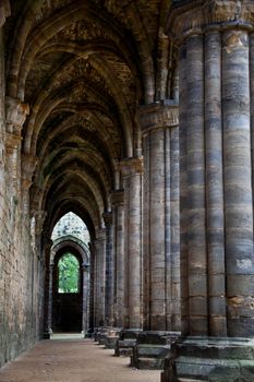 Symetrical aged gothic cloisters leading to a doorway