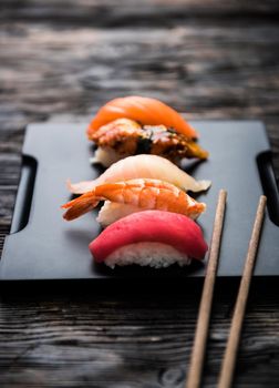 sashimi sushi set with chopsticks and soy on black background