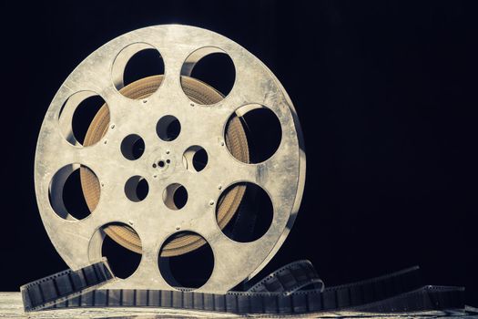35 mm film reel with dramatic lighting on a dark background - image Toned