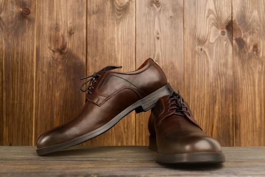 Fashionable men's classic brown shoes on a wooden background - image