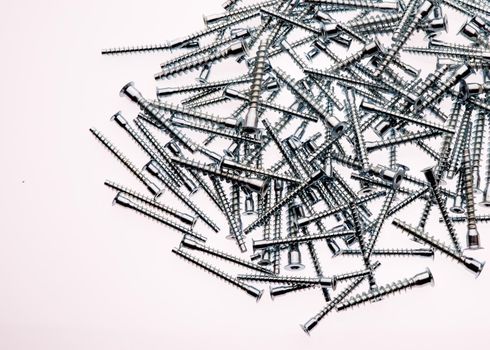 Mound of furniture screws top view on white background- image