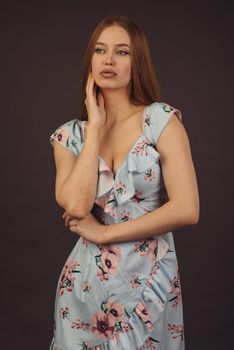 Young attractive woman posing in the studio. A full-lipped girl has problems with skin on her face and body, disease of psoriasis. She does not lose heart and lives a full life wants to become a model