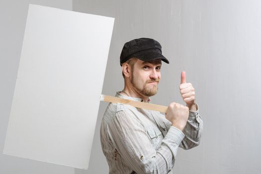 Amazed bearded man showing thumb up and leaning at copy space while standing against white background