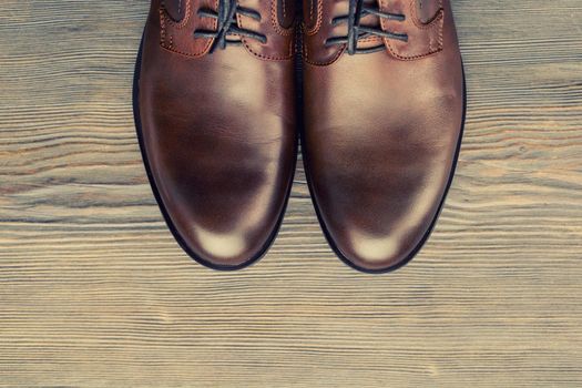 Fashionable men's classic brown shoes on a wooden background - image
