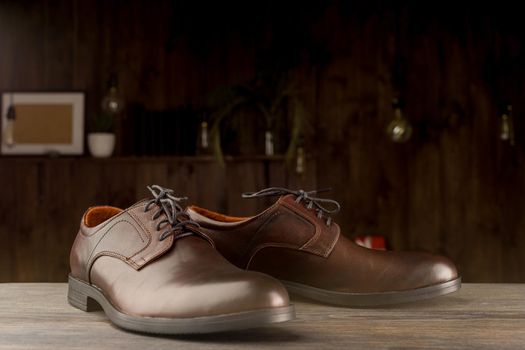 Fashionable men's classic brown shoes on a wooden background - image