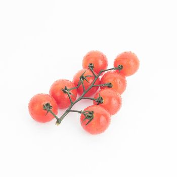 Ripe cherry tomatoes on a twig on a white background - image