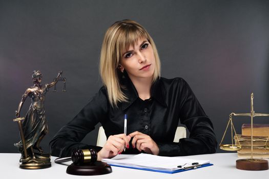 A young fair woman judge works in her office. - image