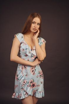 Young attractive woman posing in the studio. A full-lipped girl has problems with skin on her face and body, disease of psoriasis. She does not lose heart and lives a full life wants to become a model