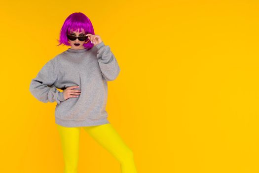 Fashion girl portrait on yellow background. Crazy style young woman in pink wig - image