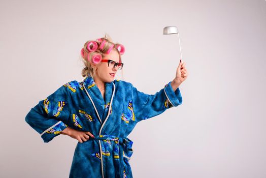 Screaming housewife in a dressing gown and curlers with a ladle in her hand.