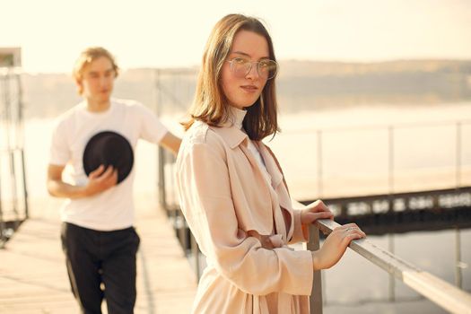 Couple by the water. Guy in a white t-shirt. Pair on a sunset background.