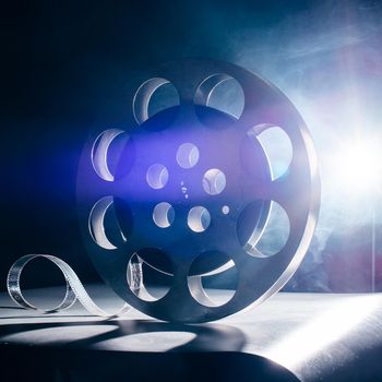Movie reel of film in retro in the blue smoke on a dark background