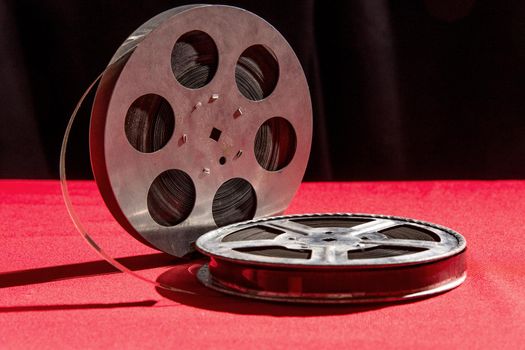 reel of film on a red table with black background