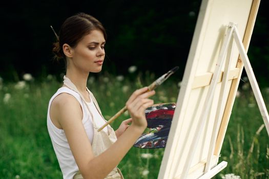 cheerful woman artist painting a picture outdoors creative art. High quality photo