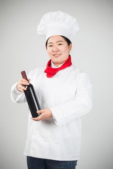 Attractive young chef or waiter holding green champagne bottle isolated in white