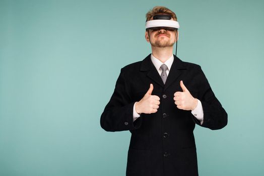 Businessman in a formal wear wearing virtual reality glasses showing thumbs up - image