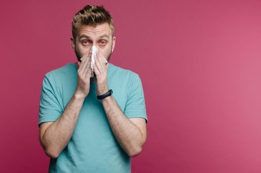 studio picture from a young man with handkerchief. Sick guy isolated has runny nose. man makes a cure for the common cold