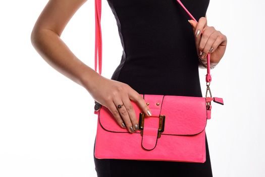 Girl in black dress with pink bag in her hand close-up