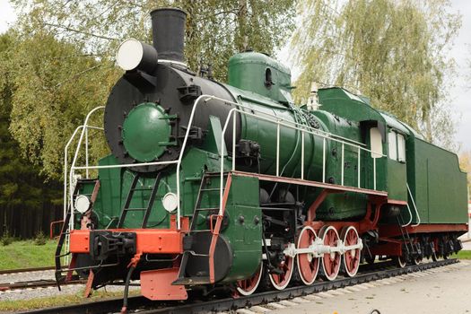 Side view of old green, steam locomotive.