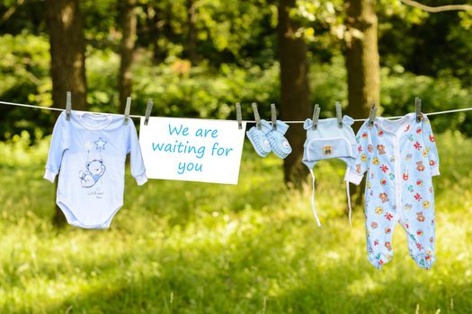 newborn Things hanging from a rope outside with the inscription plaque We are waiting for you