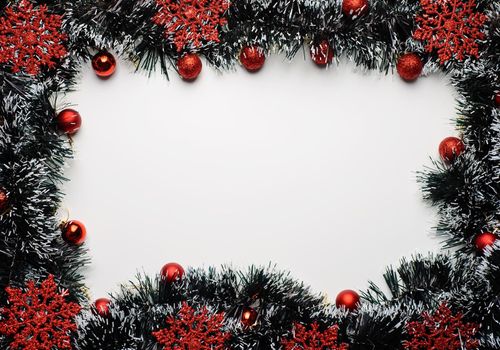 Space for New Year's wishes with tinsel and red ornaments and balls.