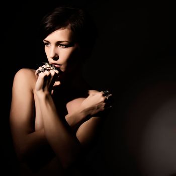 Closeup portrait of beautiful face of sexy woman with fashion makeup and gold ring on finger