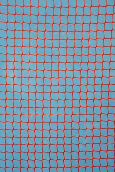 orange garden plastic fence mesh isolated on blue background.