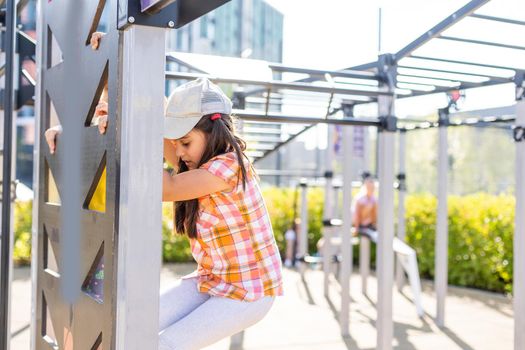 Two cute little girls having fun on a playground outdoors in summer. Sport activities for kids.