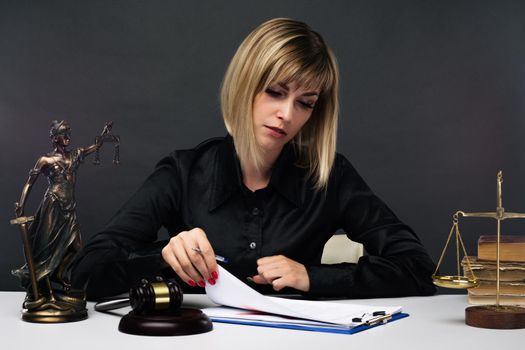 A young fair woman judge works in her office. - image