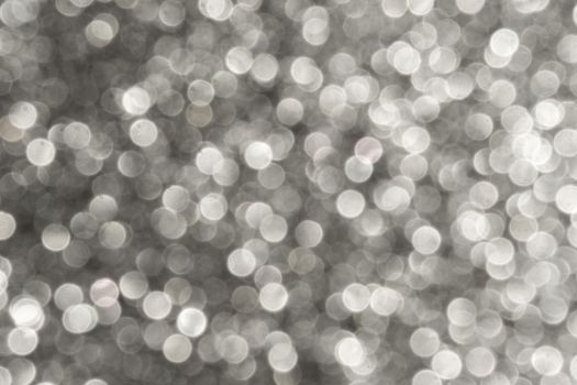 Silver Sparkling Lights Festive background with texture. Abstract Christmas twinkled bright bokeh defocused and Falling stars. Winter Card or invitation