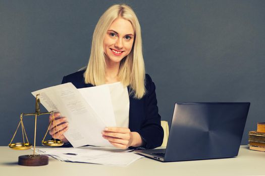 Portrait of smiling businesswoman looking at camera and smiling while working at office - image toned