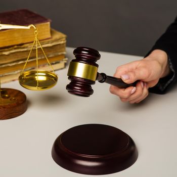 Woman Hand about to bang gavel on sounding block in the court room - image